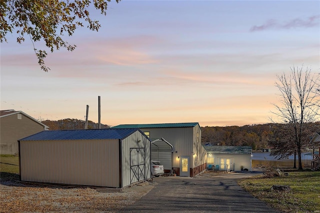 outdoor structure at dusk featuring a carport