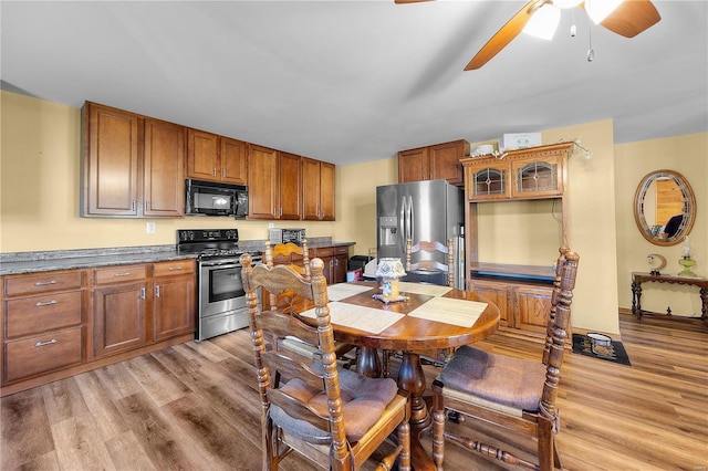 kitchen with stainless steel appliances, light hardwood / wood-style floors, and ceiling fan