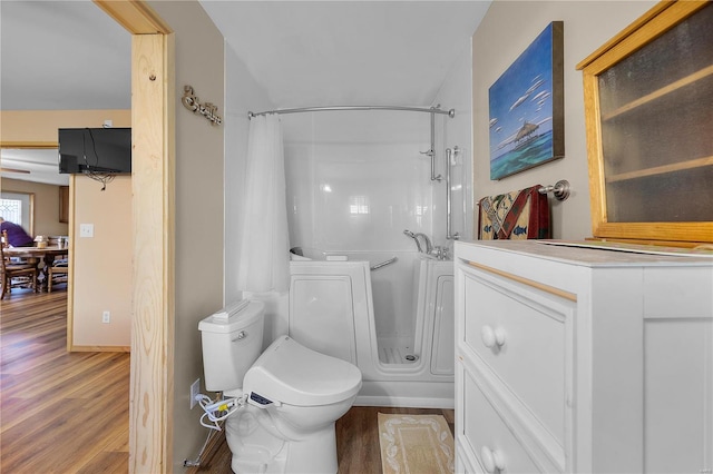 bathroom featuring hardwood / wood-style floors, toilet, and a shower with shower curtain