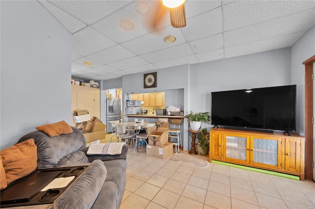 tiled living room featuring a drop ceiling and ceiling fan