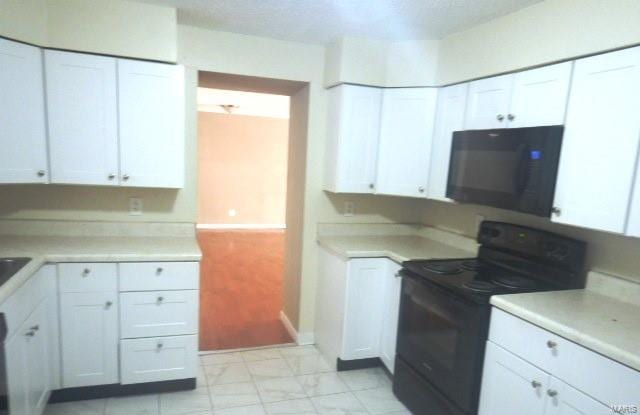 kitchen with black appliances and white cabinets