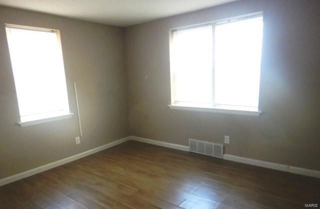 unfurnished room with dark wood-type flooring