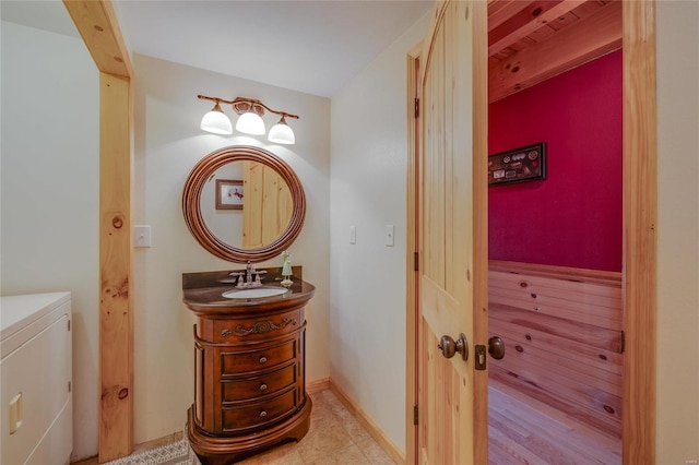 bathroom with beamed ceiling, vanity, tile patterned floors, and washer and clothes dryer