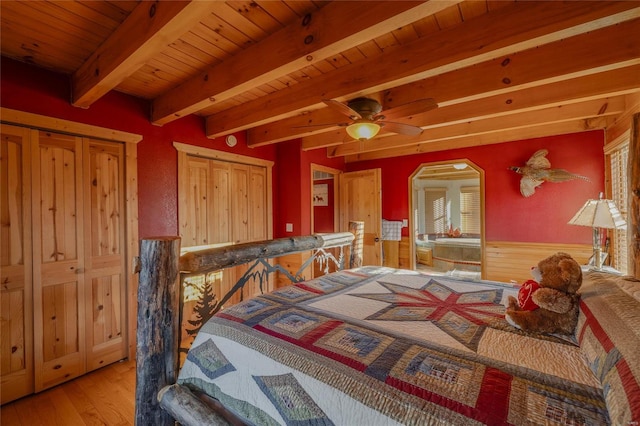 bedroom featuring beam ceiling, hardwood / wood-style flooring, ceiling fan, and wood ceiling