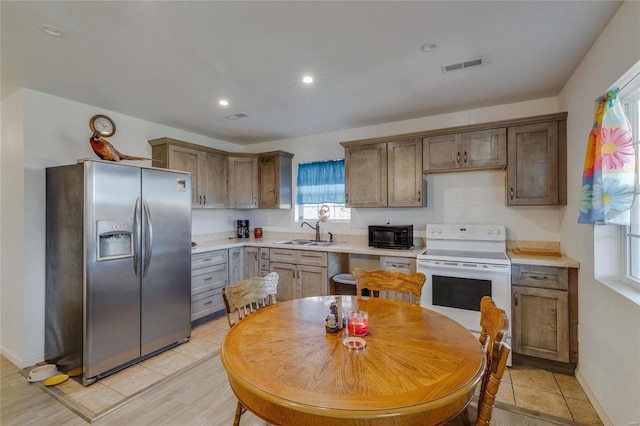 kitchen with white range with electric stovetop, stainless steel fridge with ice dispenser, sink, and light hardwood / wood-style flooring