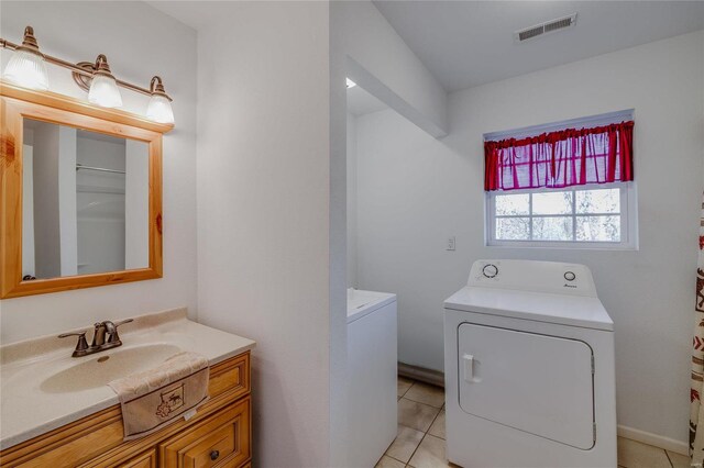 bathroom featuring tile patterned floors, vanity, and washing machine and clothes dryer