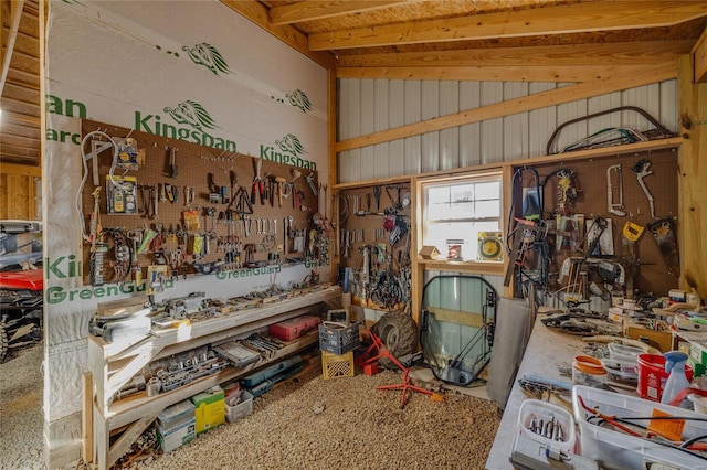 misc room with a workshop area, wood walls, and lofted ceiling with beams