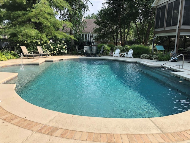 view of swimming pool with pool water feature and a patio