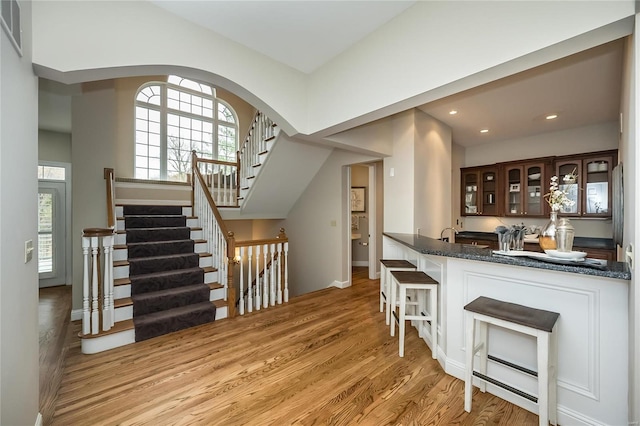 kitchen featuring kitchen peninsula, a kitchen bar, light hardwood / wood-style flooring, and a healthy amount of sunlight