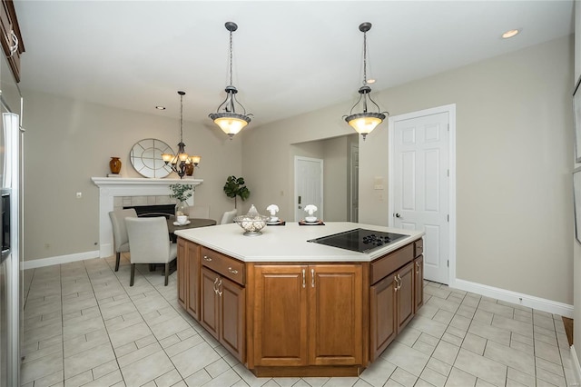 kitchen featuring pendant lighting, a center island, black electric cooktop, and a fireplace