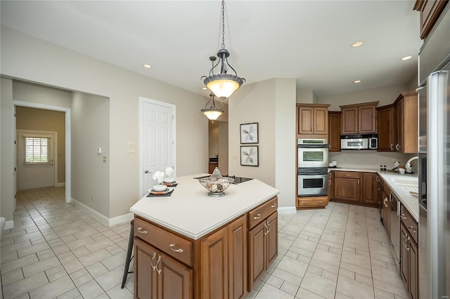 kitchen with a breakfast bar, a center island, hanging light fixtures, light tile patterned floors, and appliances with stainless steel finishes