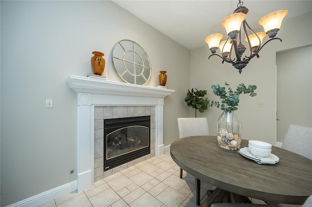 dining space with a fireplace, light tile patterned floors, and a chandelier