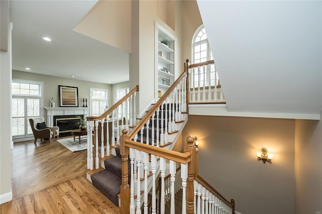 stairs with built in shelves and hardwood / wood-style flooring