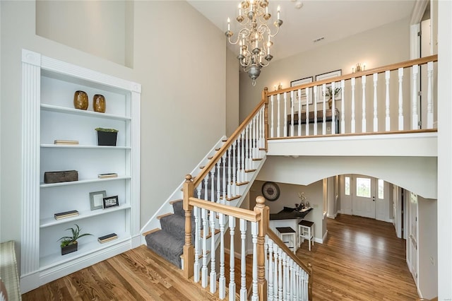 stairway with a chandelier and hardwood / wood-style flooring