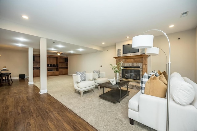 living room featuring hardwood / wood-style floors, ceiling fan, and a brick fireplace