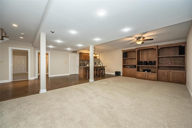 unfurnished living room featuring dark hardwood / wood-style flooring and ceiling fan