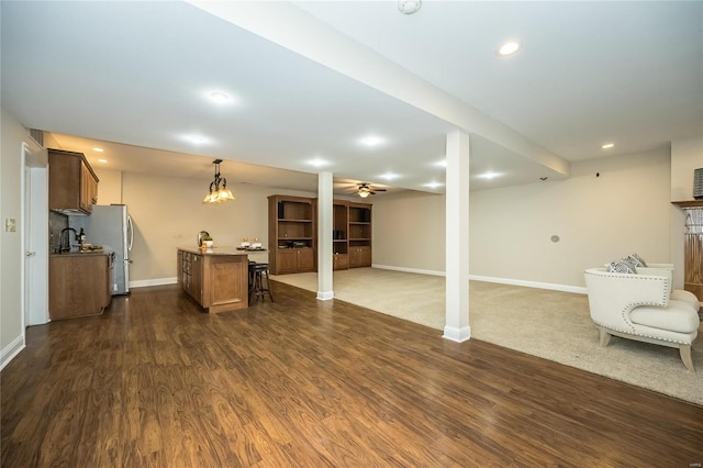 unfurnished living room featuring ceiling fan and dark hardwood / wood-style flooring