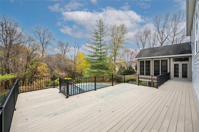 wooden deck featuring a covered pool and a sunroom