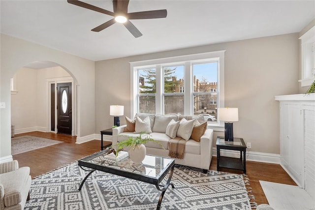 living room featuring dark wood-type flooring and ceiling fan