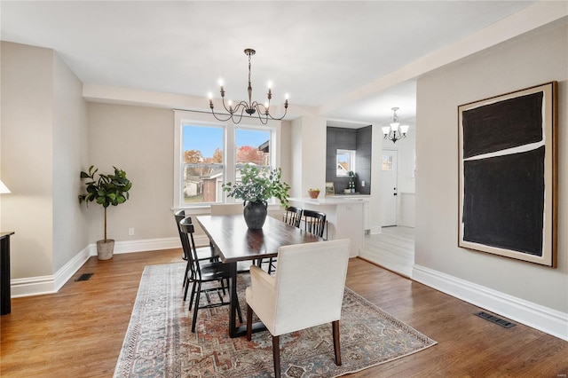 dining area featuring a notable chandelier and light wood-type flooring