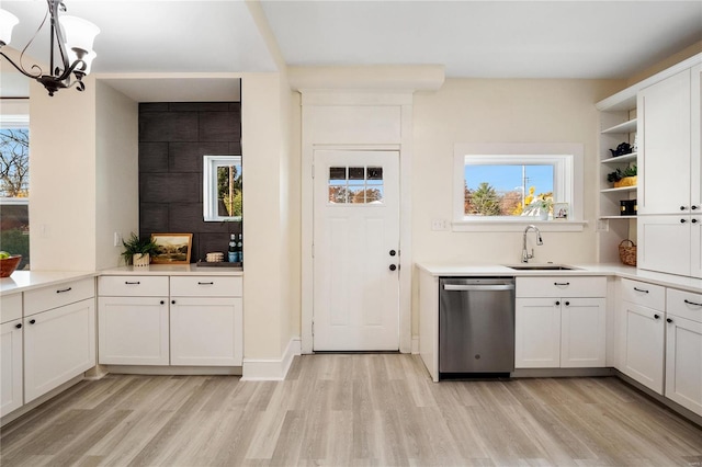 kitchen with sink, stainless steel dishwasher, white cabinets, and light wood-type flooring