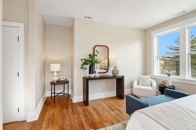 bedroom with hardwood / wood-style floors and multiple windows