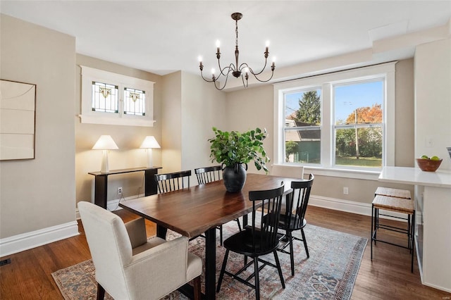 dining room with dark hardwood / wood-style flooring and a chandelier