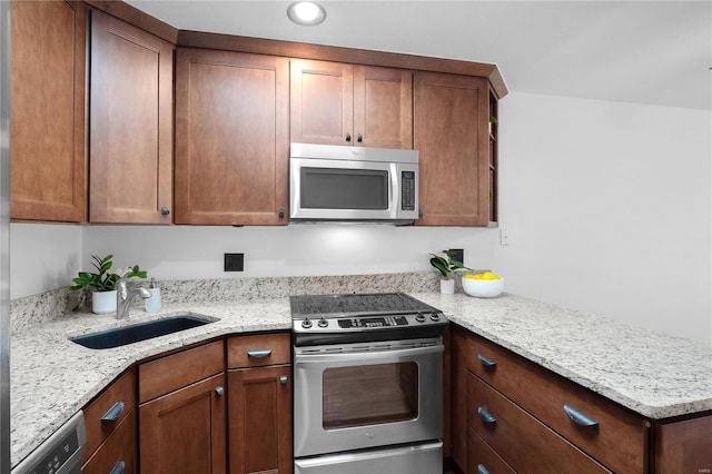 kitchen with light stone counters, sink, and stainless steel appliances