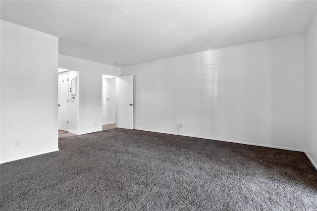 unfurnished room featuring dark colored carpet