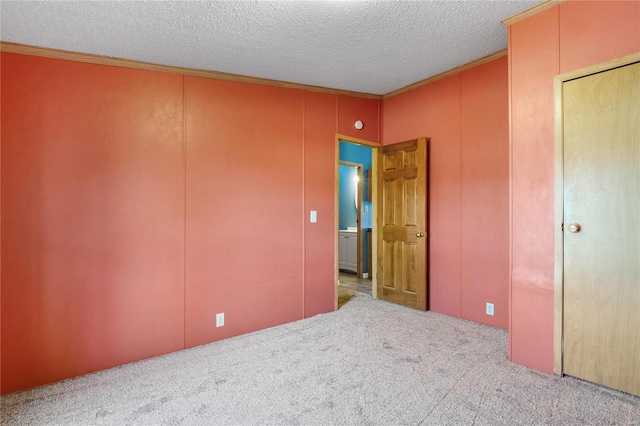 unfurnished bedroom with light carpet, a textured ceiling, and crown molding