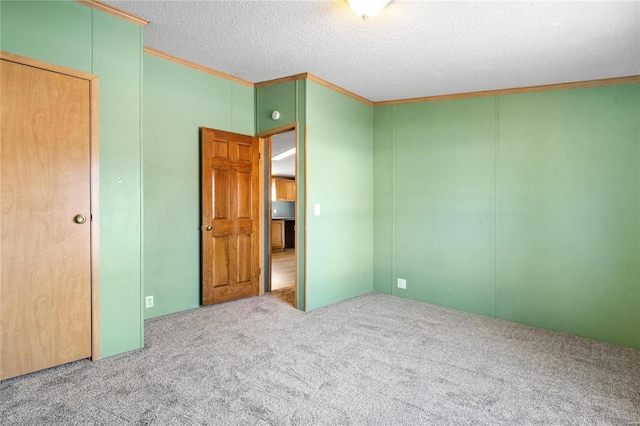 unfurnished bedroom featuring carpet flooring, crown molding, and a textured ceiling