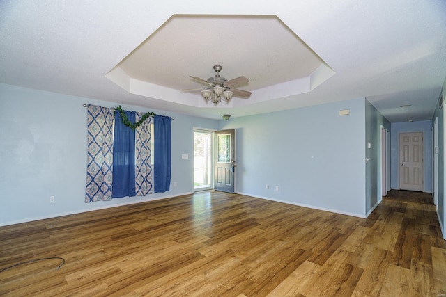 spare room with a raised ceiling, ceiling fan, and hardwood / wood-style floors