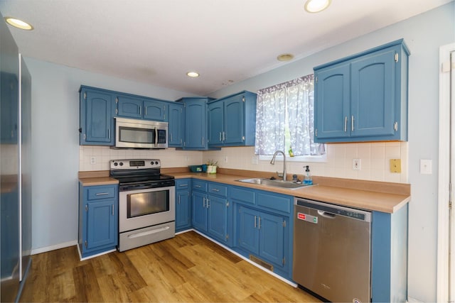 kitchen featuring stainless steel appliances, blue cabinets, and sink