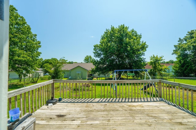 wooden terrace with a playground and a lawn