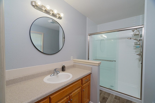 bathroom with vanity, hardwood / wood-style flooring, and walk in shower