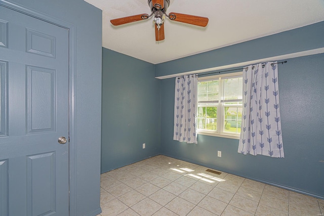 spare room featuring ceiling fan and light tile patterned flooring