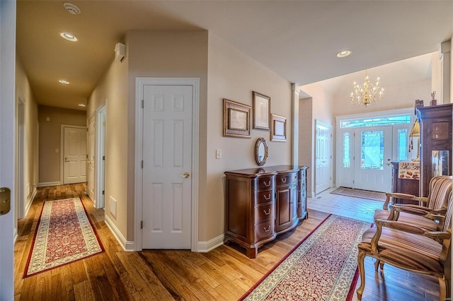 corridor with a notable chandelier and hardwood / wood-style flooring