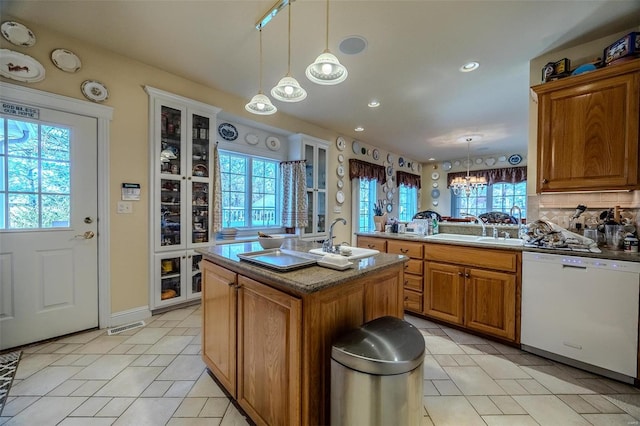 kitchen with a center island with sink, dishwasher, and a wealth of natural light