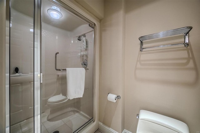 bathroom with a shower with shower door and toilet