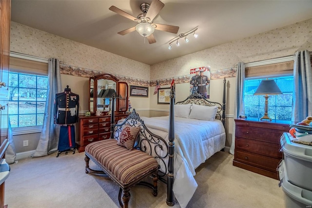 bedroom featuring ceiling fan, light colored carpet, and rail lighting