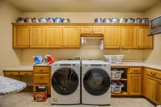 laundry room with cabinets, light tile patterned floors, and washer and dryer