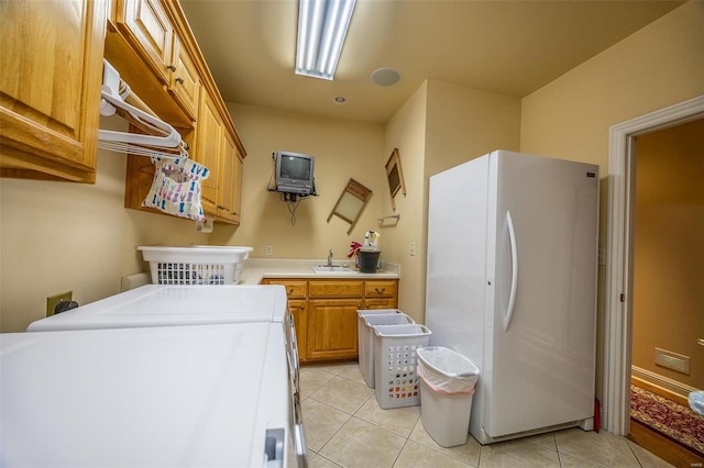 laundry area with washer and clothes dryer, light tile patterned flooring, and cabinets