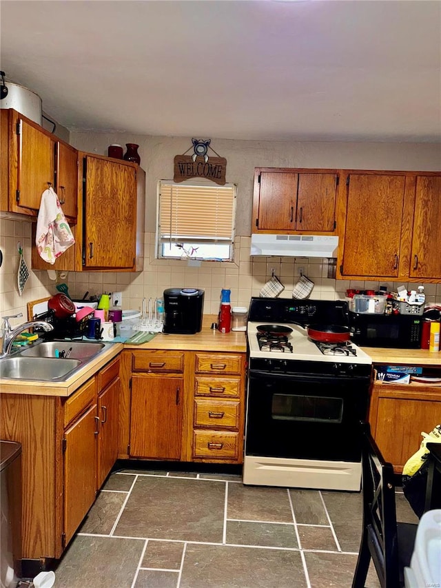 kitchen featuring backsplash, white range with gas cooktop, and sink