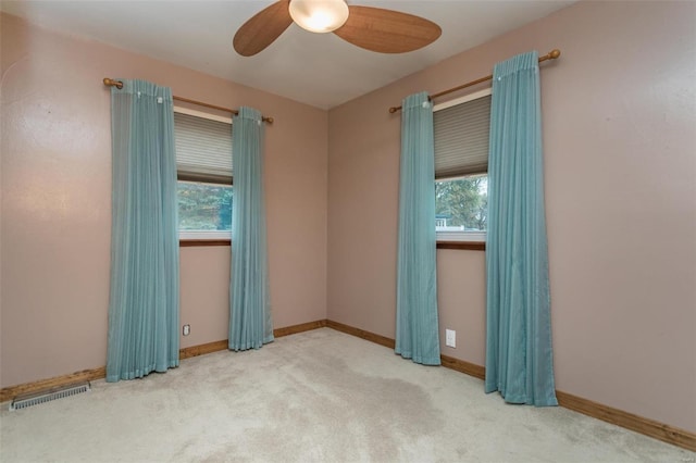 carpeted spare room featuring ceiling fan