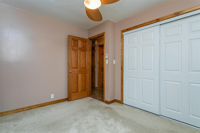 unfurnished bedroom featuring light carpet, a closet, and ceiling fan