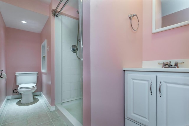 bathroom with vanity, toilet, tile patterned floors, and tiled shower