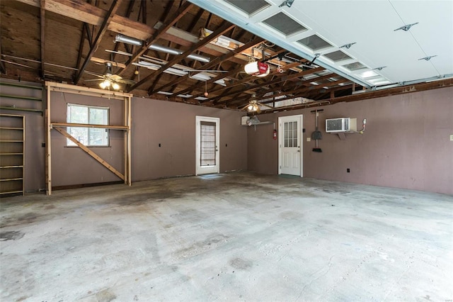 garage with a garage door opener, ceiling fan, and a wall unit AC