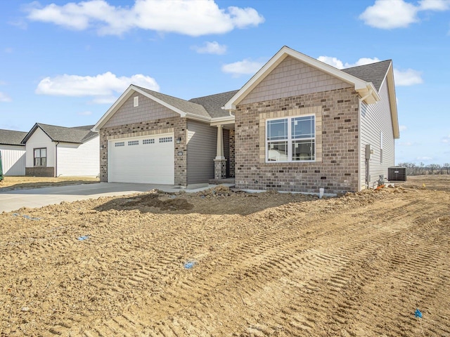 view of front of property with brick siding, central air condition unit, a garage, and driveway