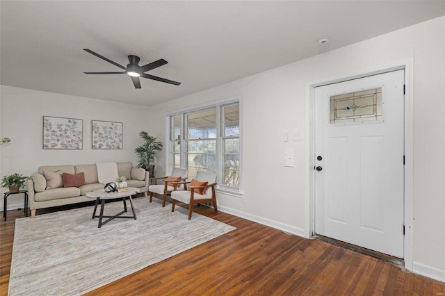 living room featuring ceiling fan and dark wood-type flooring