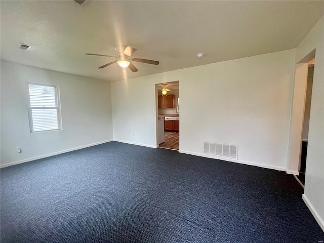 empty room with dark colored carpet and ceiling fan